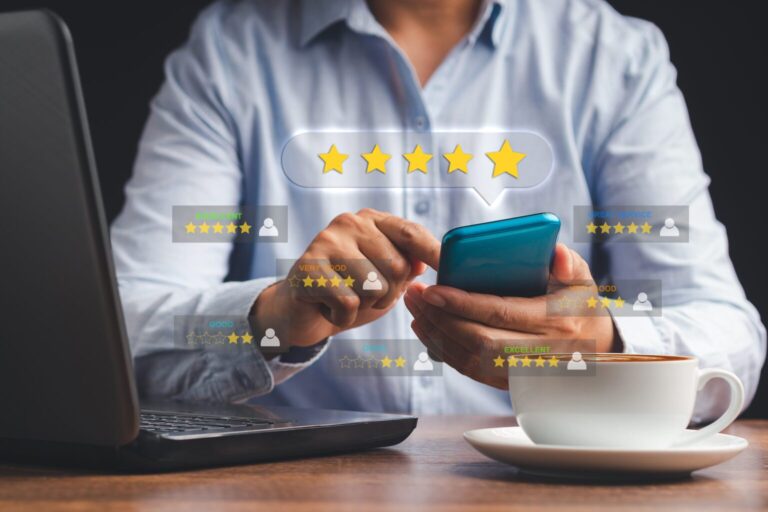 A person leaving 5-star reviews on their phone and laptop