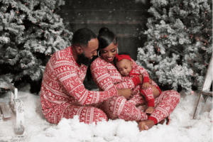 Family posing and smiling together in front of the Christmas tree