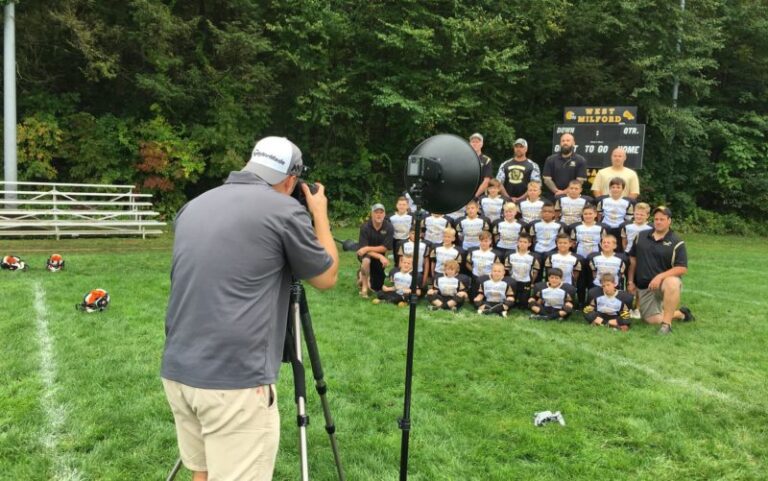 A photographer takes a photo of a kids' sports team outside