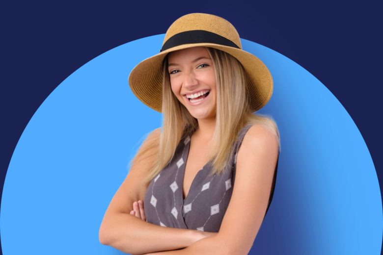 Smiling young woman in a hat posing for a senior portrait, highlighting senior photography