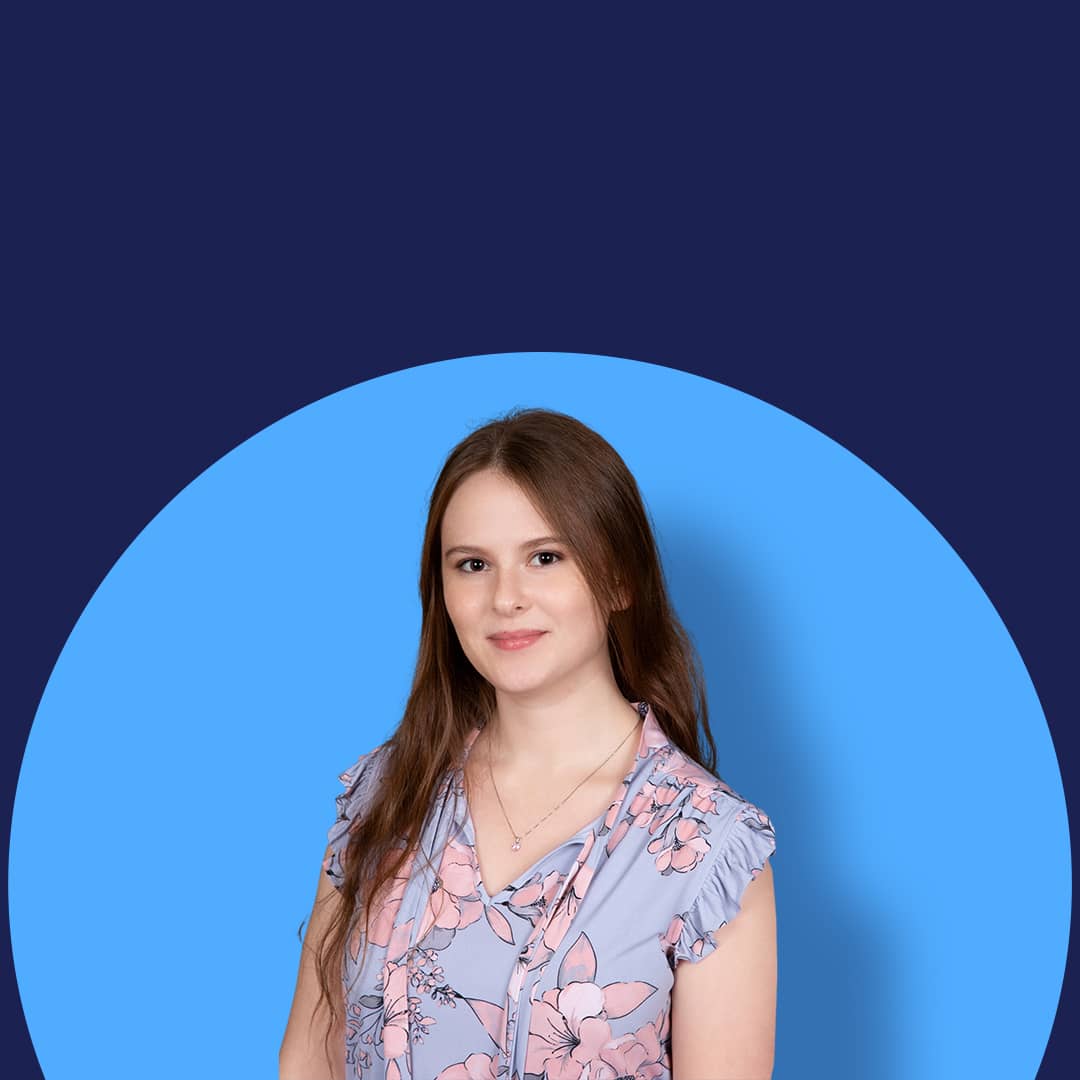 Professional headshot of a woman against a blue background, showcasing headshot photography and high-volume headshots.