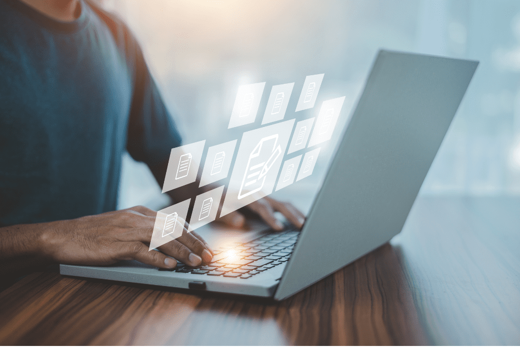 Person typing on a laptop with digital icons, showcasing digital marketing and SEO for school photography.