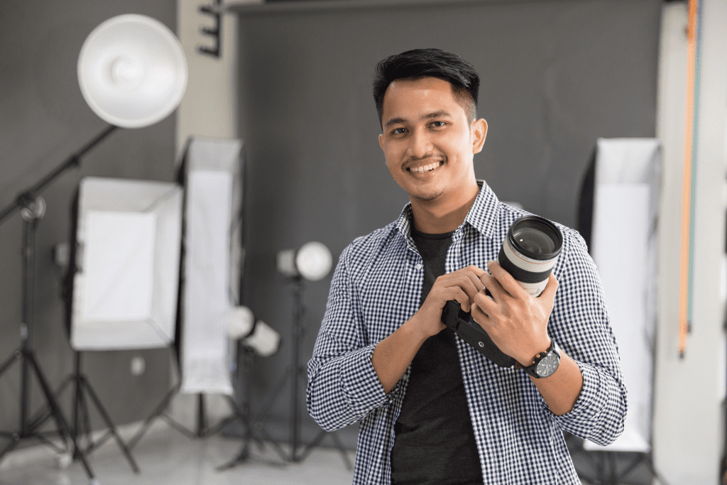 Photographer in studio smiling at camera, preparing for school picture day