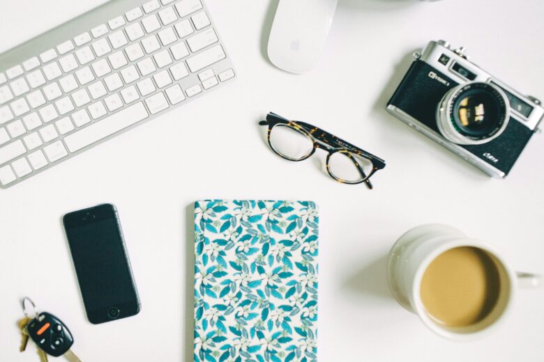 glasses, camera, notebook, keyboard on desk